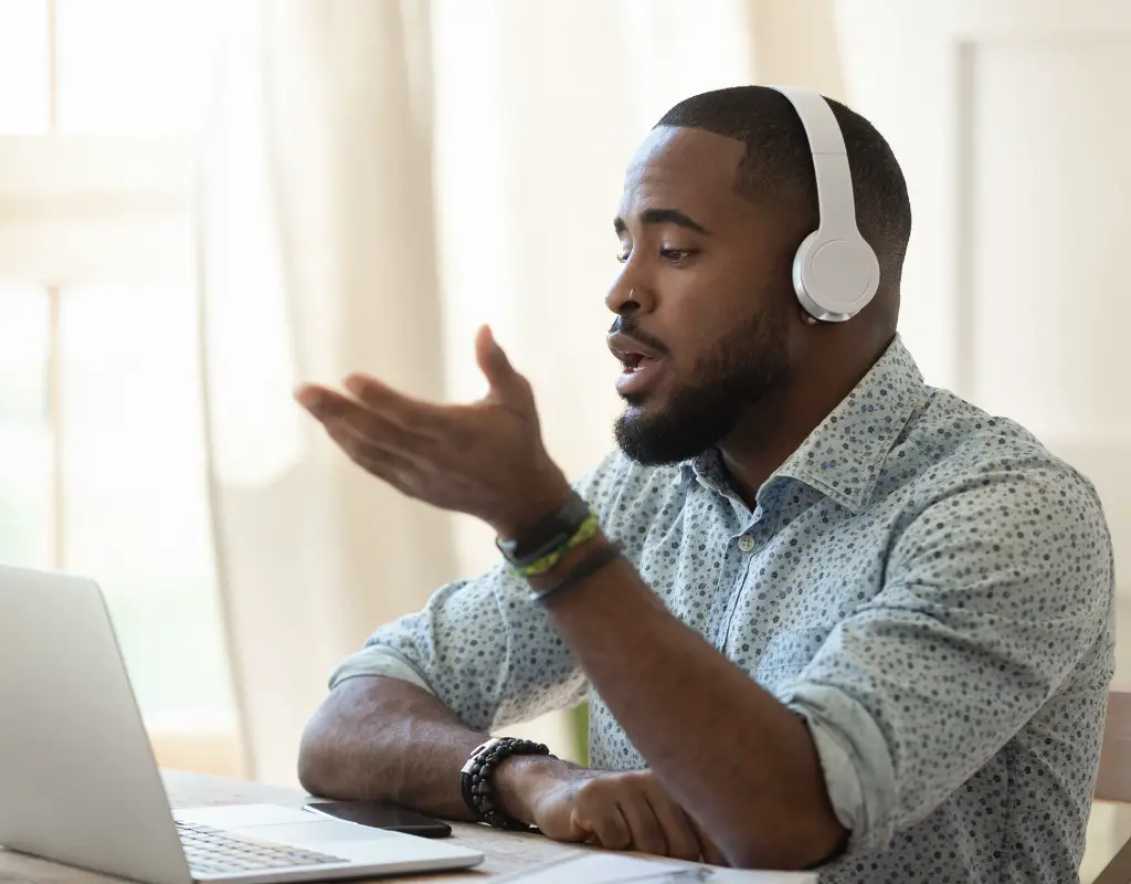 man talking on skype with laptop and headphones