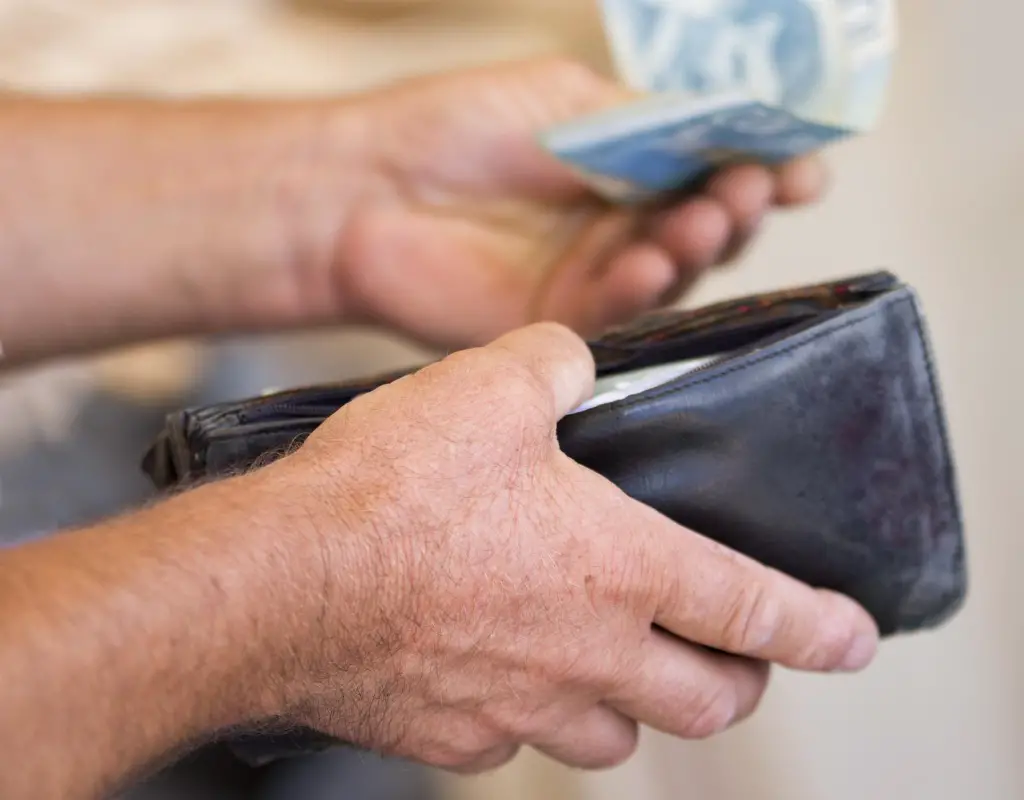 man taking reselling profit money out of wallet